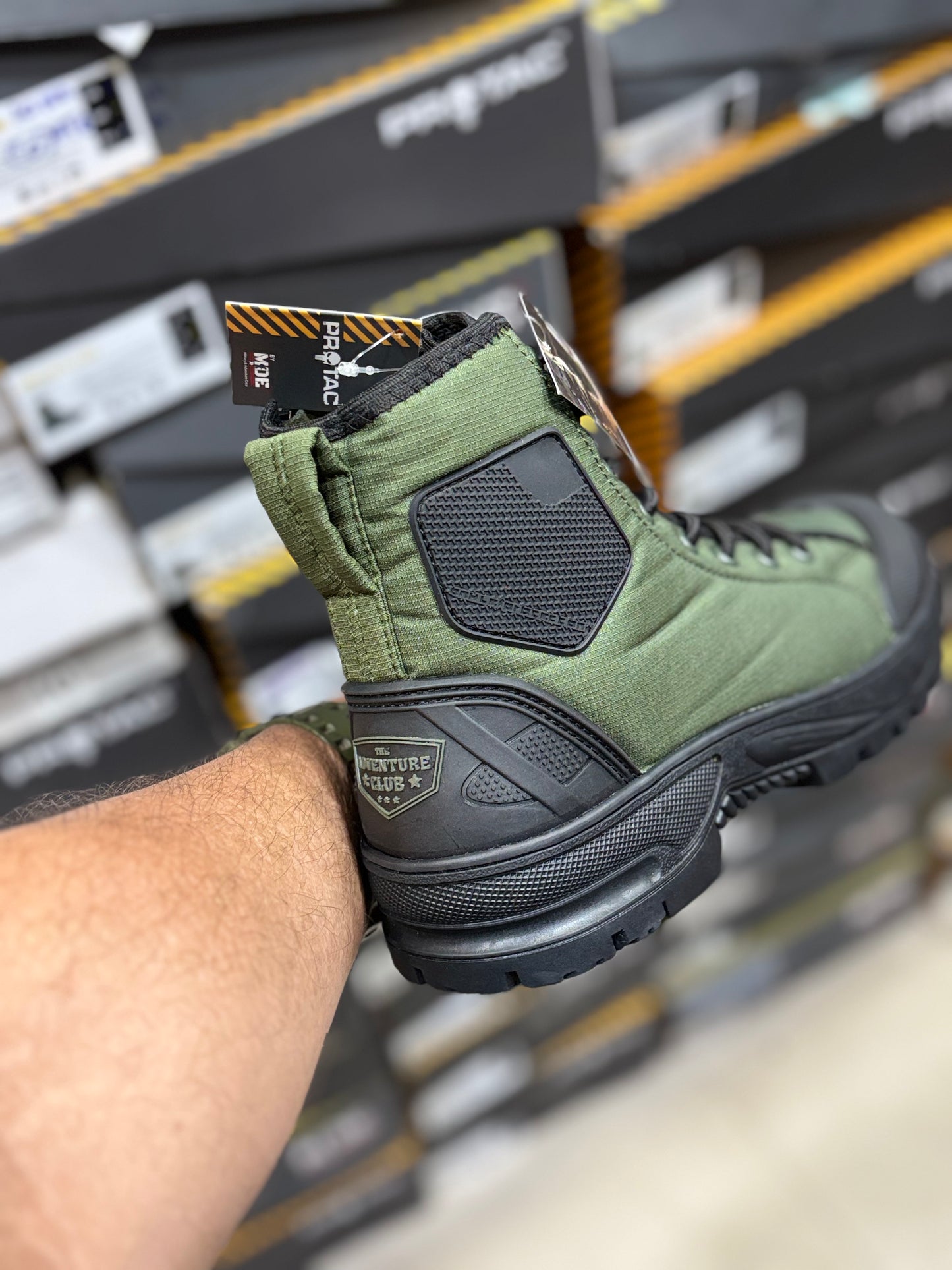 PROTAC RAPTOR Hunter 2.0 green and black boot held by a person